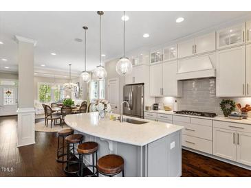 Bright, open kitchen featuring a large island with seating, stainless steel appliances, and pendant lighting at 463 Old Piedmont Cir, Chapel Hill, NC 27516