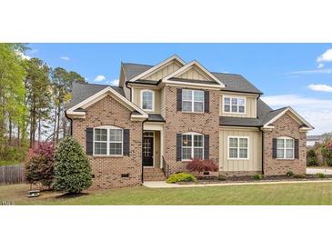 Beautiful two-story home with brick and siding, complemented by a well-manicured lawn and landscaping at 603 Goal Kick Dr, Fuquay Varina, NC 27526