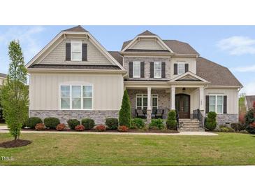 Beautiful two-story home with stone accents, covered porch, manicured lawn and tasteful landscaping at 7825 Green Hope School Rd, Cary, NC 27519