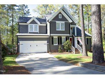 Charming two-story home with a well-manicured lawn, white garage door, and a welcoming red front door at 105 Guldahl Ct, Morrisville, NC 27560
