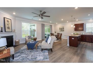 Bright living room features a fireplace, neutral paint, and hardwood floors at 108 Pronghorn Deer Ct, Garner, NC 27529
