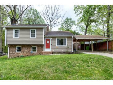 Charming two-story home with a red front door, well-maintained lawn, and covered parking at 1105 Terrace Ct, Raleigh, NC 27615
