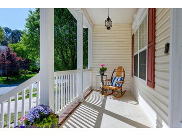 Inviting front porch with white railings and a rocking chair, perfect for relaxing outdoors at 1310 Country Club Dr, Durham, NC 27712