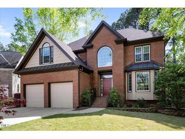 Beautiful brick home boasts mature landscaping, attached two-car garage, and covered front porch at 132 Wheatsbury Dr, Cary, NC 27513