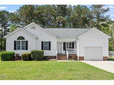Charming single-story home featuring well-maintained landscaping and an attached garage, nestled among mature trees at 1752 Cobblestone Dr, Creedmoor, NC 27522