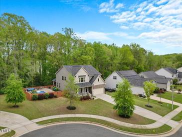 Beautiful home with a pool and a lovely landscaped yard on a sunny day at 190 Bingham Creek Dr, Garner, NC 27529