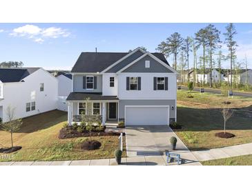 Charming two-story home with a two-car garage, neatly landscaped front yard, and a combination of siding at 20 Carolina Maple Dr, Franklinton, NC 27525