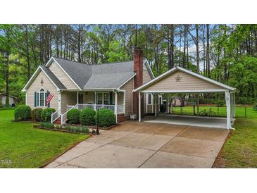 Charming home featuring a cozy front porch, well-manicured landscaping, and a convenient carport at 2024 Country Trails Dr, Clayton, NC 27520