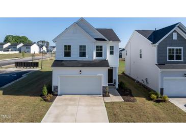Charming white two-story home with a two-car garage and well-maintained landscaping at 205 Fig Tree Bnd, Zebulon, NC 27597