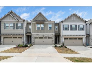 Charming townhome exterior with stone accents, neutral siding, and a two-car garage, set in a well-maintained neighborhood at 2129 Mars Hill Ln, Apex, NC 27502