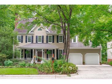Charming two-story home with a welcoming front porch, mature trees, and a two-car garage at 307 Parkmeadow Dr, Cary, NC 27519