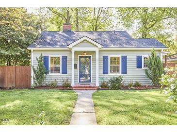Charming home featuring a cozy design and vibrant blue shutters, with a well-maintained lawn at 315 Greenwood Dr, Durham, NC 27704