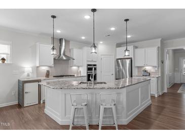 Bright kitchen with granite countertops, stainless steel appliances, and a central island with bar seating at 3262 Ripley River Rd, New Hill, NC 27562