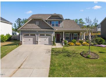 Charming two-story home featuring a well-maintained lawn, a two-car garage, and tasteful landscaping at 405 Club Center Dr, Youngsville, NC 27596