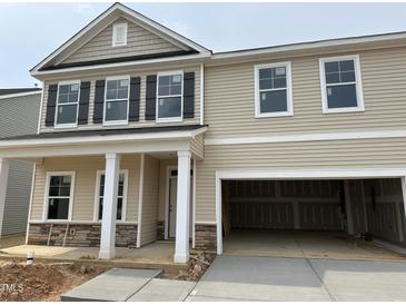 Two-story home featuring a beige siding, white trim, black shutters, and a two-car garage at 4105 Shadbush St, Raleigh, NC 27616