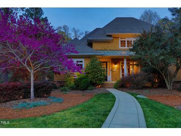 Charming two-story home with a walkway leading to the front door, enhanced by a vibrant tree at 10001 Sandcreek Ct, Chapel Hill, NC 27517