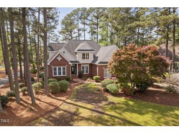 Beautiful brick two-story home with lush landscaping, mature trees, and a welcoming front entrance at 101 Preston Arbor Ln, Cary, NC 27513