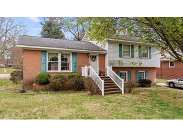 Charming brick and vinyl home featuring a welcoming front porch and well-maintained landscaping at 101 W Thorndale Dr, Oxford, NC 27565