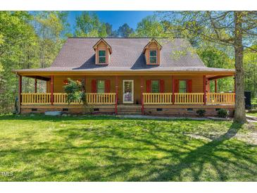 Charming two-story home featuring a covered front porch, dormer windows and mature trees at 105 Hobson Pl, Louisburg, NC 27549