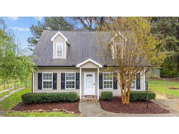 Charming home featuring neutral siding, black shutters, dormer windows, and well-maintained landscaping at 120 Stillmeadow Dr, Louisburg, NC 27549