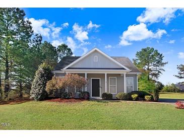 Charming single-story home features a well-manicured front lawn and inviting covered porch at 13 Parkers Pointe Dr, Benson, NC 27504