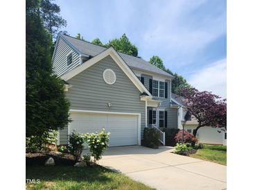 Two-story home featuring an attached garage, a well-maintained lawn, and traditional architecture with gray siding at 2424 Horizon Hike Ct, Raleigh, NC 27603