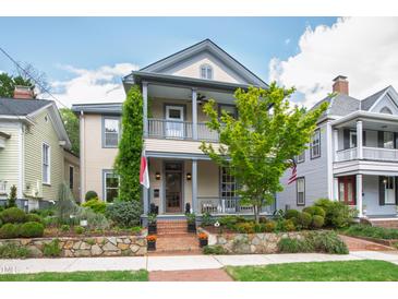 Charming two-story home with covered porches, landscaped yard, and brick pathway creating curb appeal at 315 Oakwood Ave, Raleigh, NC 27601