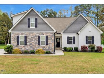Charming two-story home with stone and board and batten siding and a well-manicured lawn at 4304 S Greg Allen Way, Oxford, NC 27565