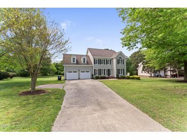 Charming two-story home with a two-car garage, well-maintained lawn, and a long driveway at 5424 Westminster Ln, Fuquay Varina, NC 27526