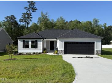 Traditional ranch style home featuring a well-manicured lawn and a two-car garage at 58 Heatherglenn Cir, Princeton, NC 27569