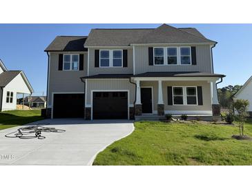 Charming two-story home featuring a spacious two-car garage and a well-manicured front lawn at 61 Heatherglenn Cir, Princeton, NC 27569