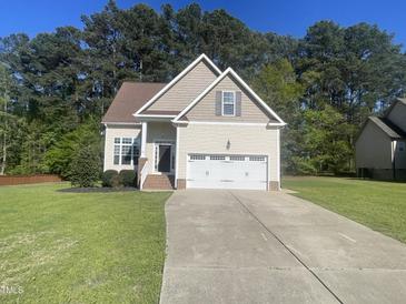Charming home featuring a two-car garage, well-manicured lawn, and inviting curb appeal at 66 Saddle Ln, Lillington, NC 27546