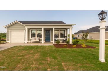 Charming single-story home featuring a covered front porch with stylish seating at 67 Fern Ridge Dr, Cameron, NC 28326