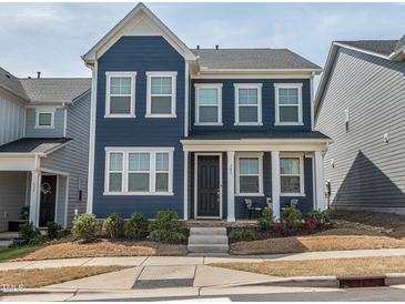 Charming blue two-story home featuring a covered front porch and well-manicured landscaping at 781 Cormiche Ln, Wake Forest, NC 27587