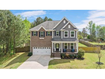 Charming two-story home with a brick and gray siding exterior, covered porch, and well-manicured lawn at 8016 Parker Mill Trl, Fuquay Varina, NC 27526