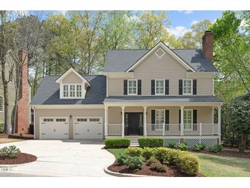 Charming two-story home featuring a covered front porch, well-manicured landscaping, and a two-car garage at 102 Parkbranch Ln, Cary, NC 27519