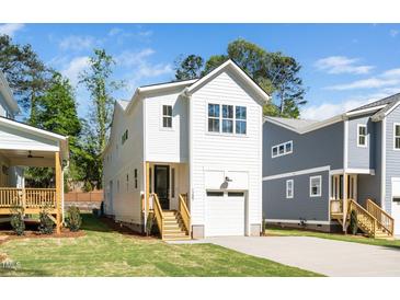 Charming white two-story home with a one-car garage and well-manicured lawn at 1207 Chaney Rd, Raleigh, NC 27606
