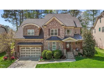 Charming brick home with a two-car garage and beautifully landscaped front yard at 1512 Piazzo Ct, Apex, NC 27502