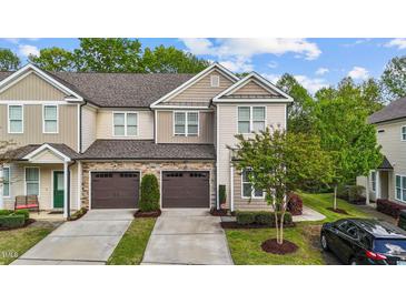 Charming townhome featuring a stone facade, two-car garage, and well-maintained landscaping at 265 Mariah Towns Way, Garner, NC 27529