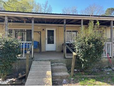 Charming covered front porch with seating area, accessible via wooden ramp and steps at 308 San-Lee Drive Dr, Sanford, NC 27330