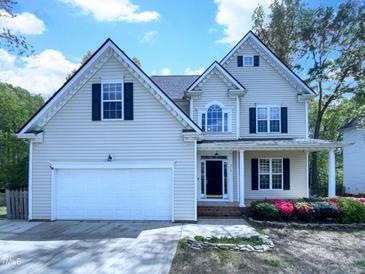 Charming two-story home with landscaped front yard, attached garage, and inviting front porch at 312 Sarazen Dr, Clayton, NC 27527