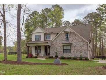 Charming two-story home featuring stone accents, neutral siding, and a well-manicured lawn at 3881 Whisperwood Ct, Youngsville, NC 27596