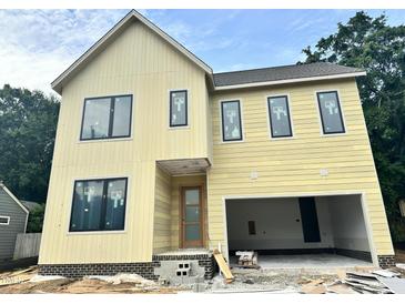 Two-story yellow home with black frame windows and an attached garage under construction at 406 Columbia Dr, Raleigh, NC 27604