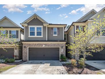 Charming brick and siding two-story townhouse with an attached two-car garage at 521 Rockcastle Dr, Cary, NC 27519
