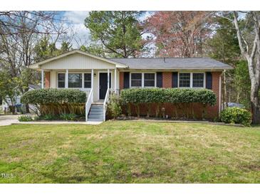 Charming single-story brick home with a well-manicured lawn and inviting front porch at 5218 Revere Rd, Durham, NC 27713