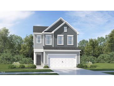 Charming two-story home with gray siding, a two-car garage, and a beautifully landscaped front yard at 748 Swim Cave Ln, Wendell, NC 27591