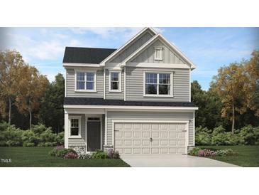 Charming two-story home with gray siding, well-manicured lawn and a two car garage at 761 Swim Cave Ln, Wendell, NC 27591