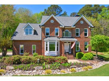 Charming brick home with manicured landscaping and a welcoming entrance with an American flag displayed at 8059 Hogan Dr, Wake Forest, NC 27587