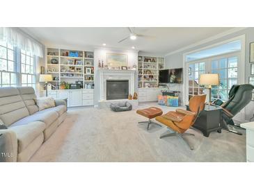 Bright living room boasts a cozy fireplace, built-in shelves, and access to the outdoor living space at 104 Buckeye Ln, Chapel Hill, NC 27516