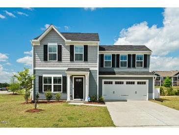 Charming two-story home featuring a gray exterior, a two-car garage, and a well-maintained lawn at 1110 Bent Willow Dr, Durham, NC 27704